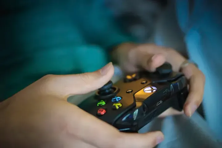 An image of a person holding an Xbox One gamepad.